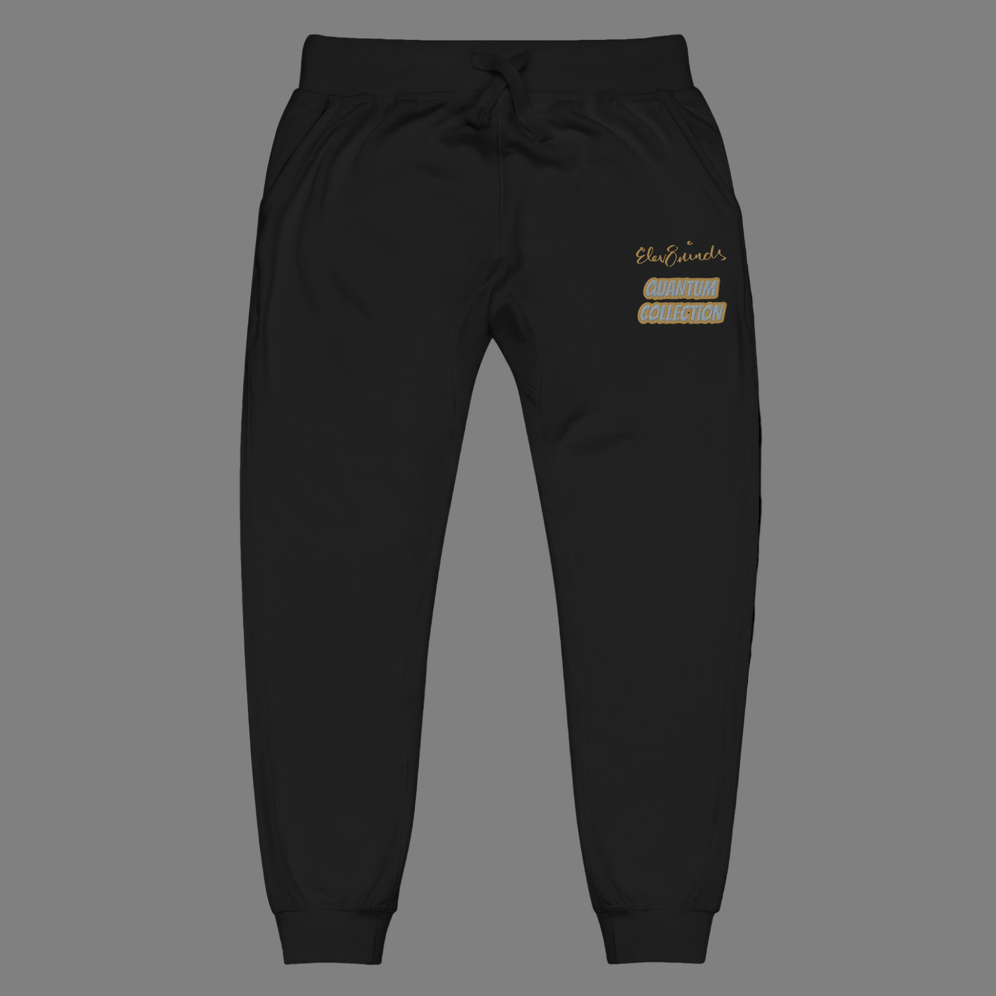 Black jogger pants with gold and silver embroidery on a Grey background