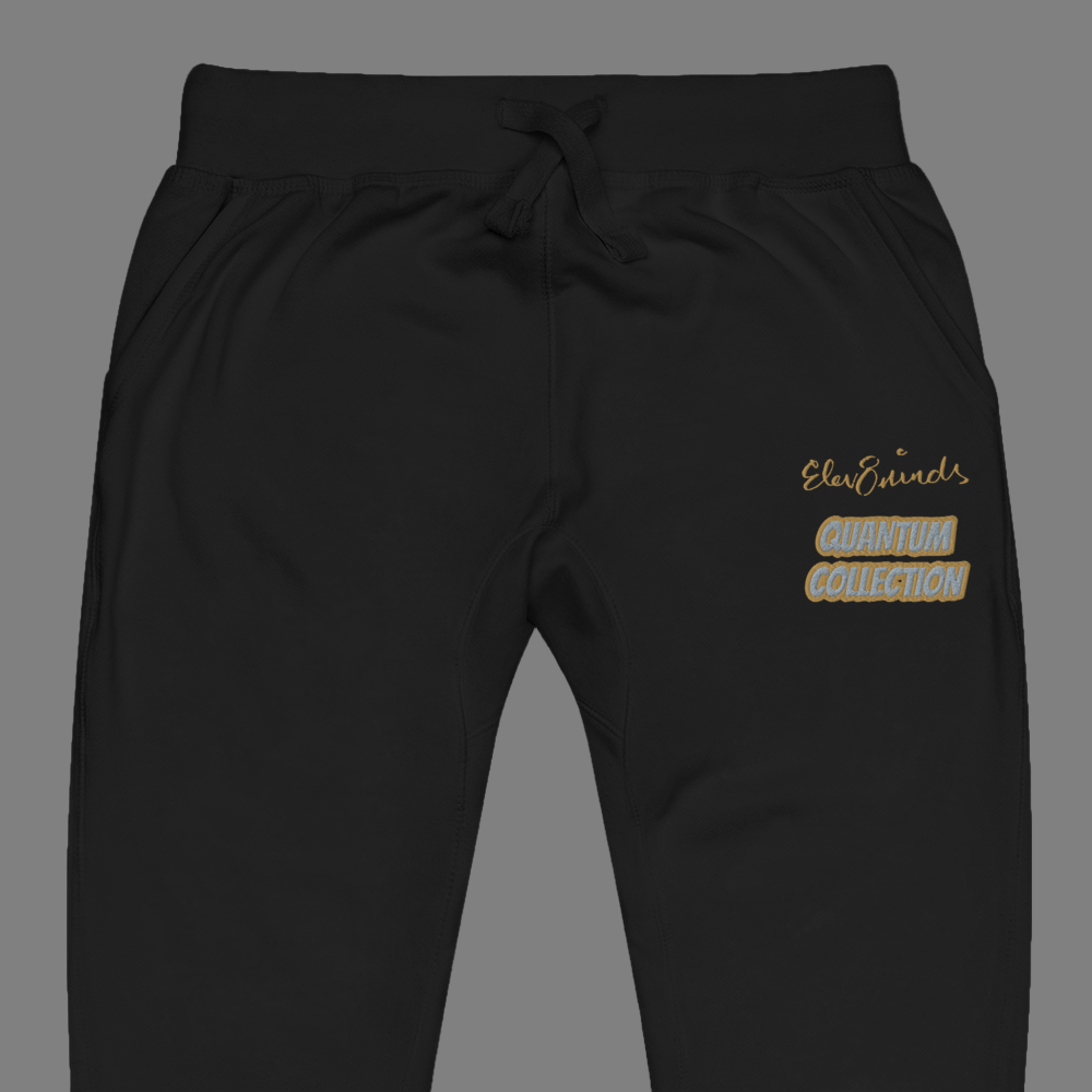 Black sweatpants with gold and silver text on a Grey background